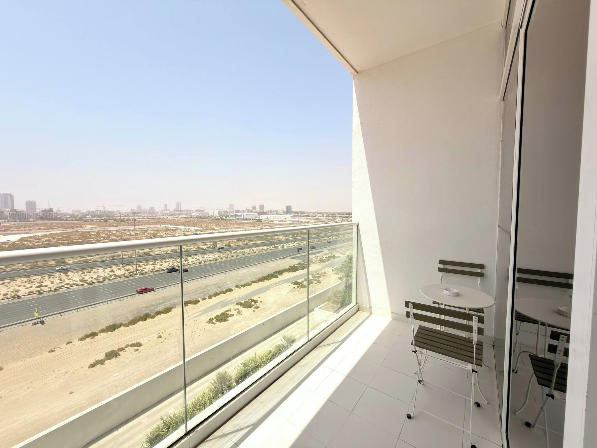 A balcony with a view of a highway and cityscape.