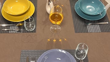 Una mesa de comedor dispuesta con platos, vasos y cubiertos.