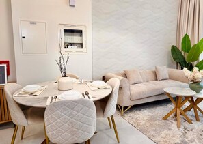 Ein modernes Wohnzimmer mit einem runden Esstisch, zwei Sofas und einem Couchtisch.