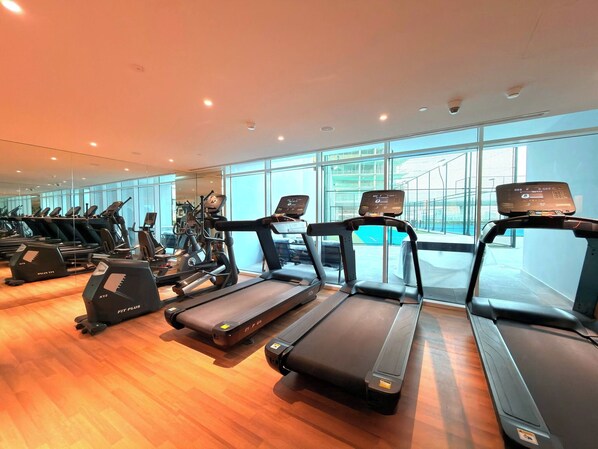 Una palestra con tapis roulant, cyclette e macchinari per l'allenamento della forza.