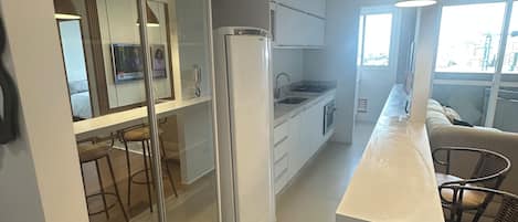 Eine moderne Küche mit Kühlschrank, Spüle und Essbereich mit Stühlen.