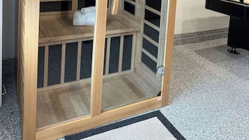 A wooden cabinet with glass doors, a white towel, and a framed picture on the wall.