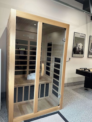 A wooden cabinet with glass doors, a white towel, and a framed picture on the wall.