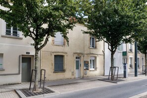 A street with buildings, trees, and a sidewalk. - Le Laon - Climatisation - Proche tram (Reims)