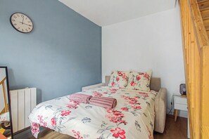 Ein Schlafzimmer mit einem Bett, einer Uhr und einem Nachttisch.