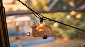 A string of lights with a dome-shaped ornament hanging from a window. - Vintage Airstream Caravel Retreat Near Beach & Sea-Tac (Des Moines)