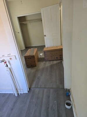 Ein Flur mit einer weißen Tür, einem Schrank und zwei Kartons auf dem Boden.