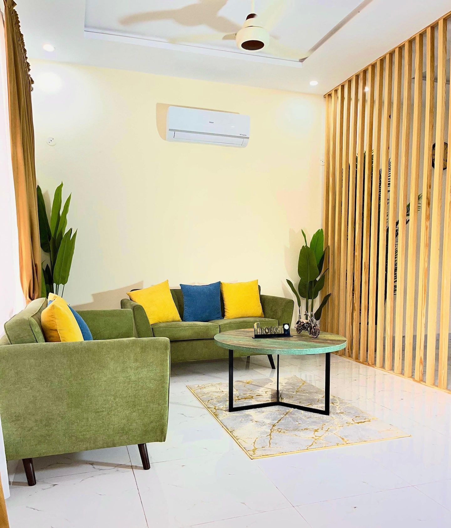A living room with a sofa, armchairs, a coffee table, and a wooden partition.