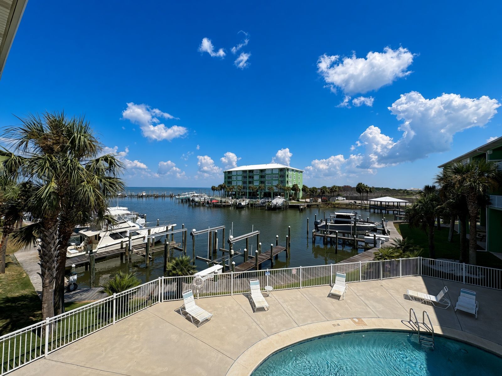 A marina with boats, a pool, and a building with a view of the water.