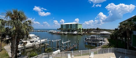 Un port de plaisance avec des bateaux, une piscine et un bâtiment offrant une vue sur l’eau.