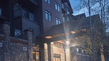 A multi-story building with a stone facade and a covered entrance.