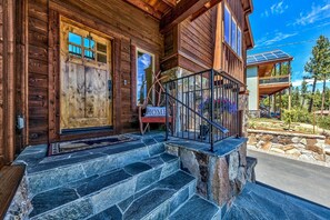 A wooden cabin with a stone staircase leading to a porch, a sign reading 'HOME,' and a solar panel on the roof. - 4 Bedroom Mountain Contemporary Views! (South Lake Tahoe)