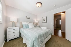 A bedroom with a bed, bedside tables, a lamp, a framed sign, and a door leading to another room. - 3829S Heavenly View Across from Heavenly Cal Base Lodge (South Lake Tahoe)