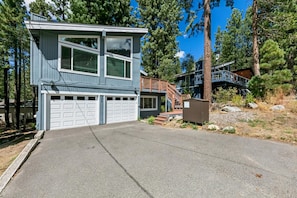 A two-story house with a garage, a staircase leading to a deck, and a clear driveway. - 3829S Heavenly View Across from Heavenly Cal Base Lodge (South Lake Tahoe)