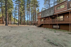A cabin-style building with a wooden deck and a staircase leading to a second floor. - Upgraded Condo Close to all Tahoe activities! (South Lake Tahoe)