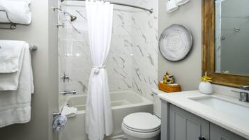 A bathroom with a shower, toilet, and sink.