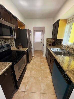A kitchen with a microwave, refrigerator, stove, and dishwasher.