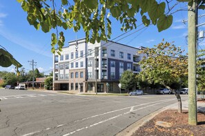 A multi-story building with a flat facade, large windows, and a parking lot in front.