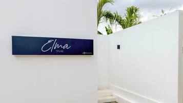 Un intérieur moderne avec un mur blanc et une enseigne bleu foncé portant le nom « Elma » et un logo.
