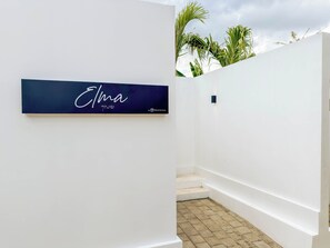 Un intérieur moderne avec un mur blanc et une enseigne bleu foncé portant le nom « Elma » et un logo.
