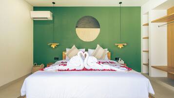 Quarto de hotel com cama, ar condicionado fixado na parede, um objeto decorativo na parede e um armário de prateleiras de madeira.