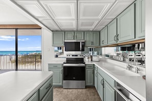 A modern kitchen with a built-in oven, microwave, and stainless steel appliances. - Windward 108 (Panama City Beach)