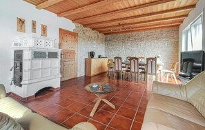 A living room with a fireplace, a dining area with a table and chairs, and a television. - Beautiful home in Kemmenau with house a panoramic view (Kemmenau)