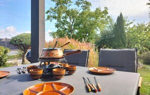 An outdoor dining setup with a table, chairs, and a portable stove. - Beautiful home in Kemmenau with house a panoramic view (Kemmenau)