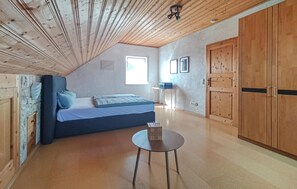 A bedroom with a bed, a small table, and a wardrobe. - Beautiful home in Kemmenau with house a panoramic view (Kemmenau)