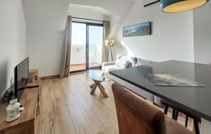 A modern living room with a sofa, a glass coffee table, and a TV. - Apartamento Benalmadena vistas (Benalmadena)