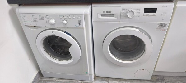 Two front-loading washing machines with control panels, placed side by side in a laundry area. - Room-small Double Room in Chelmsford Fre (Chelmsford)