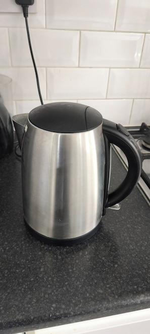 A stainless steel mug on a kitchen counter with a black handle. - Room-small Double Room in Chelmsford Fre (Chelmsford)