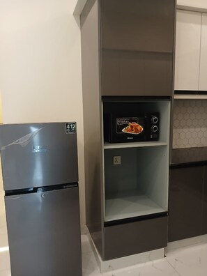 Una cuina amb un frigorífic d'acer inoxidable i un forn de sobretaula.