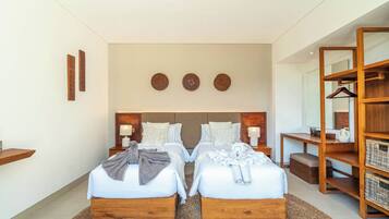 Habitación de hotel con cama doble, mesitas de noche, cabecero de madera, espejo, armario y estante en la pared.