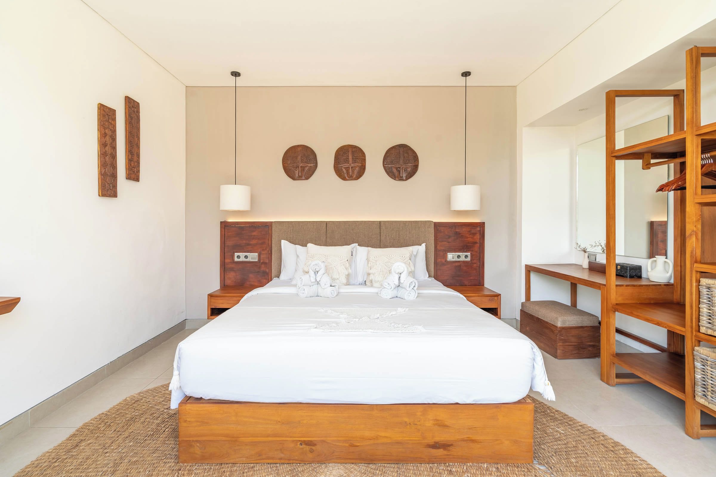 Een moderne slaapkamer met een groot bed, een houten hoofdbord, nachtkastjes en een inbouwkast.
