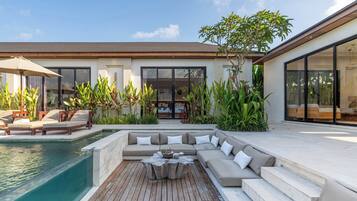 Ein moderner Außenbereich mit Pool, Sitzgelegenheiten und einem großen Glas Eingang.
