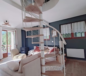 A room with a spiral staircase, a sofa, a chair, and a radiator. - Welcome to Skimoon! Our family chalet with panoramic view of Haut Verdon valley (Villars-Colmars)