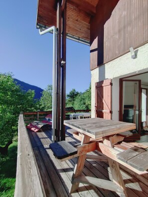 A wooden deck with a picnic table, a wooden fence, and a building with a sloped roof. - Welcome to Skimoon! Our family chalet with panoramic view of Haut Verdon valley (Villars-Colmars)