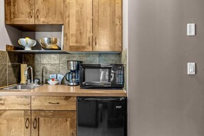 A kitchen with wooden cabinets, a sink, a coffee maker, a microwave, and a dishwasher. - Elevated Alpine Nest Sleeps 4 Hot tub + Gym! (Golden)