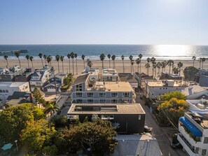 A coastal residential area with modern houses, a beach, and a pier in the background. - Venice Beach House (Los Angeles)
