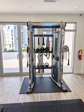 Ein Fitnessraum mit Klimmzugstange, Gewichte und Kabelzugmaschine.