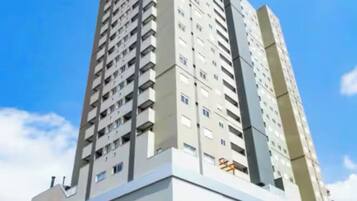 Um edifício alto com vários andares, janelas amplas e um telhado plano.