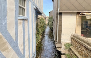 A narrow waterway between buildings with a stone wall on one side and a building with a window on the other. - Lovely apartment in Pont-Audemer with WiFi (Pont-Audemer)