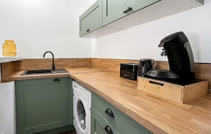 A compact kitchen with a washing machine, a coffee maker, and a toaster. - Lovely apartment in Pont-Audemer with WiFi (Pont-Audemer)
