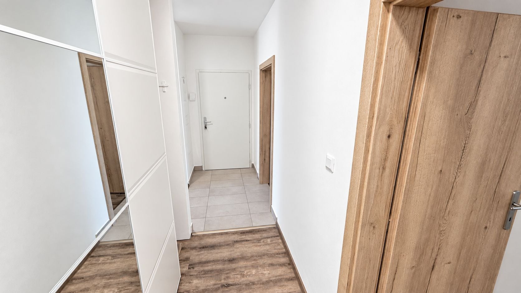 Bright entry hall with mirrored wardrobe and modern wood accents