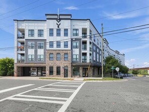 A multi-story building with a modern architectural design, featuring a mix of brick and white facade, large windows, and balconies. - Brand-new Luxury Furnished Penthouse in Noda 30 Night Mid-term Rental (Charlotte)