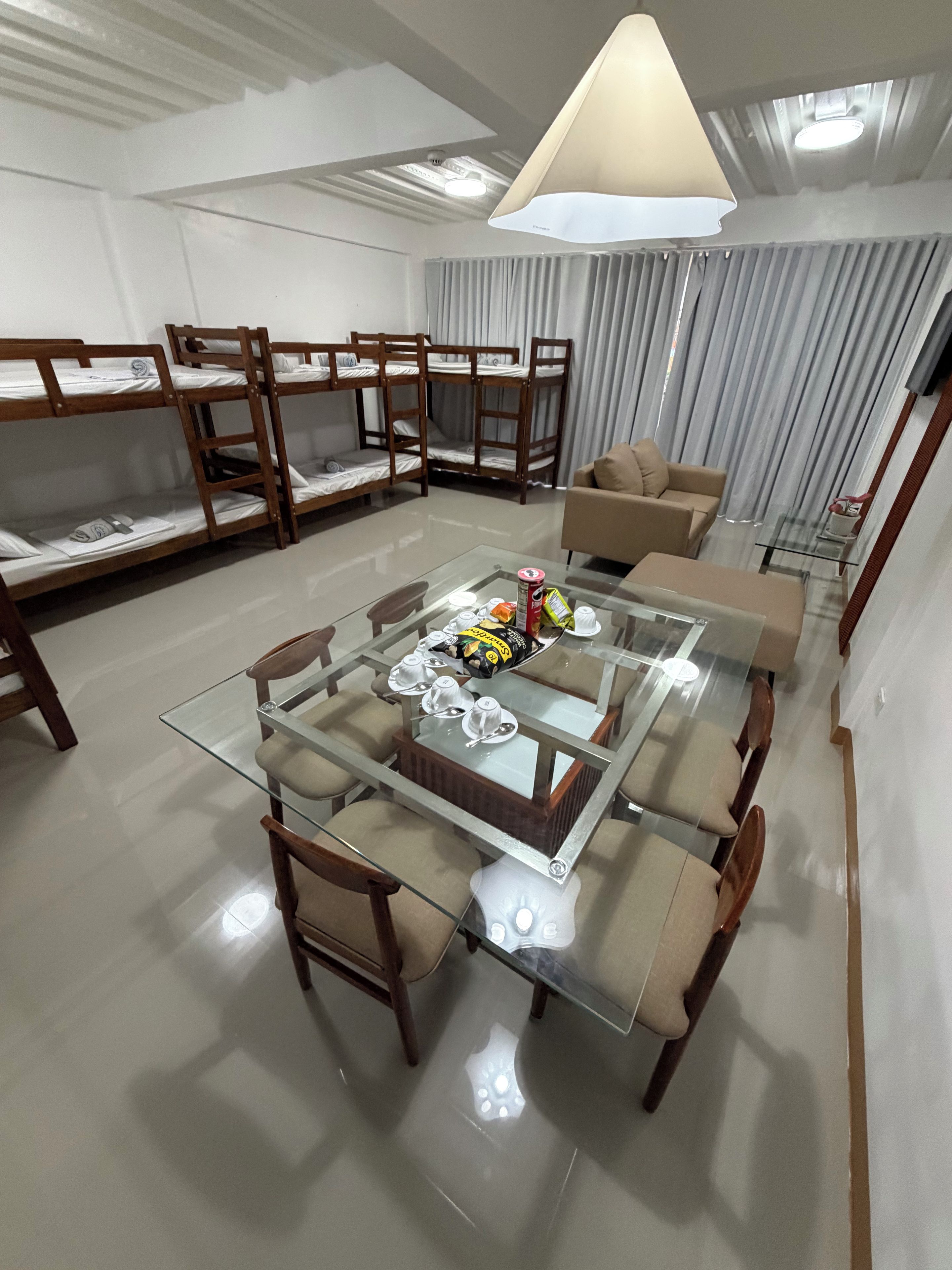 A modern living room with bunk beds, a glass coffee table, and a sofa.