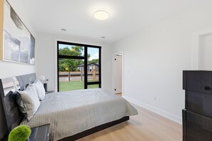 Ein Schlafzimmer mit Bett, Fenster und Tür.