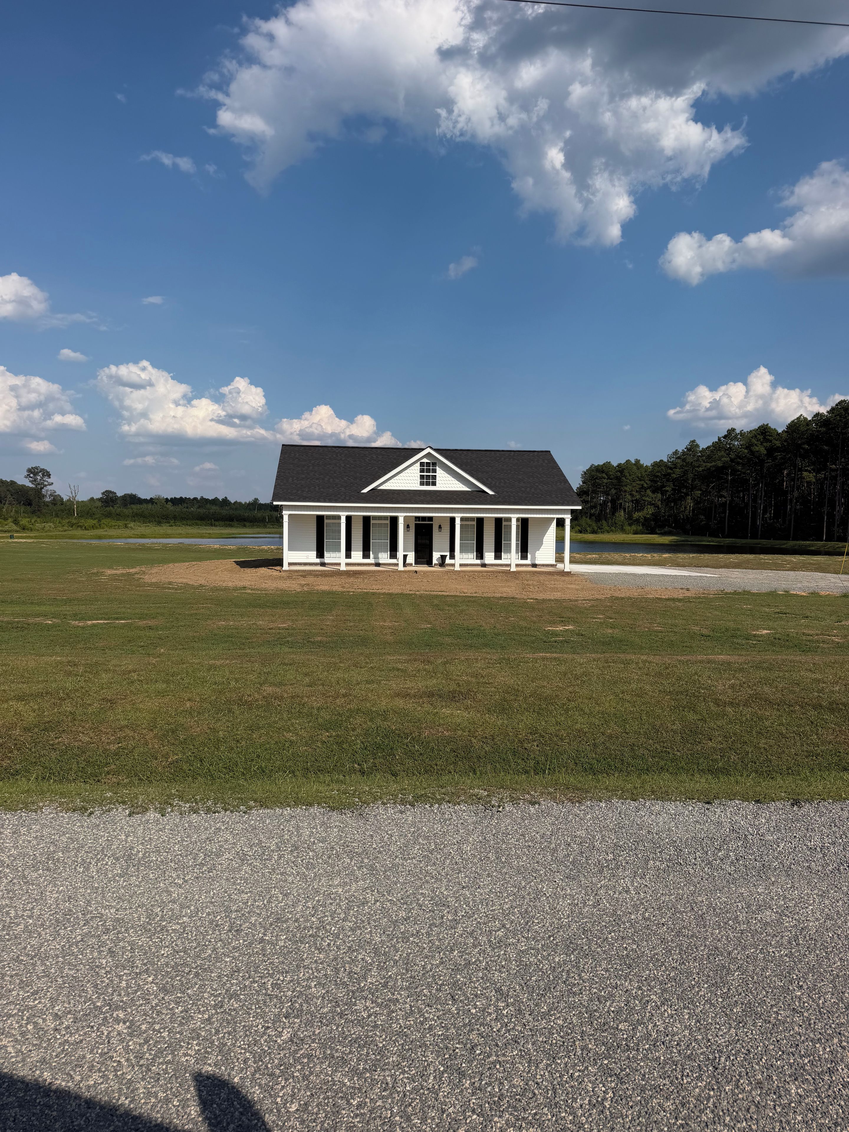 A single-story building with a gabled roof, a front porch, and a symmetrical facade.