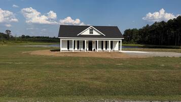 A single-story building with a gabled roof, a front porch, and a symmetrical facade.